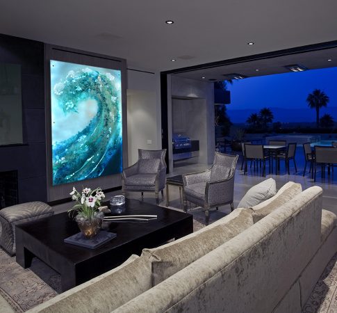 Modern living room with view of swimming pool and patio at dusk